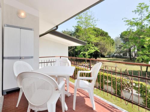 una mesa blanca y sillas en un balcón con vistas en Apartment Villaggio Delfino-2 by Interhome, en Bibione