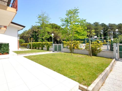 un jardín con césped y una valla en Apartment Villaggio Delfino-2 by Interhome, en Bibione
