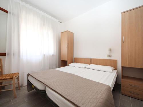 sypialnia z dużym łóżkiem i oknem w obiekcie Apartment Casa Debora-1 by Interhome w mieście Rosolina Mare