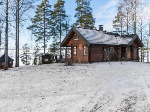 una piccola cabina in legno nella neve con gli alberi di Holiday Home Puolen hehtaarin metsä by Interhome a Haapaniemi