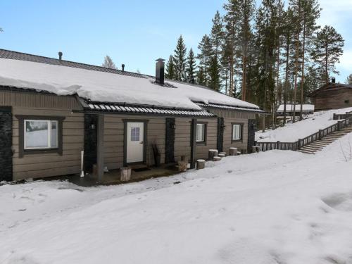 ケウルーにあるHoliday Home Kivipirtti by Interhomeの屋根に雪が積もったキャビン、雪で覆われた私道