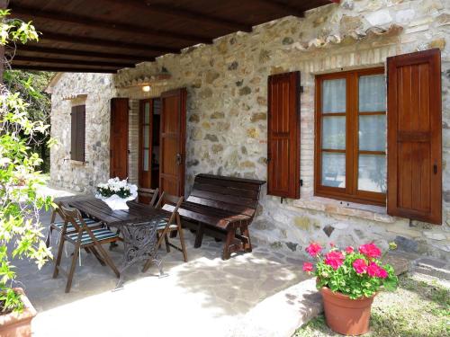 a patio of a stone house with a table and chairs at Holiday Home Podere Cafaggiolo-2 by Interhome in Volterra