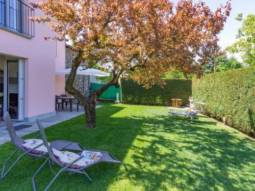 une cour avec deux chaises et un arbre dans l'établissement Holiday Home Orchidea - CCO555 by Interhome, à Colico
