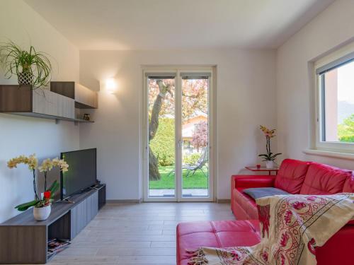 un salon avec un canapé rouge et une télévision dans l'établissement Holiday Home Orchidea - CCO555 by Interhome, à Colico