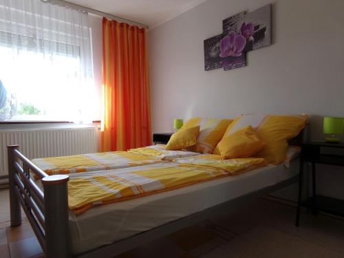 1 dormitorio con 1 cama con sábanas amarillas y ventana en Agroturystyka u Willima, en Mechnica