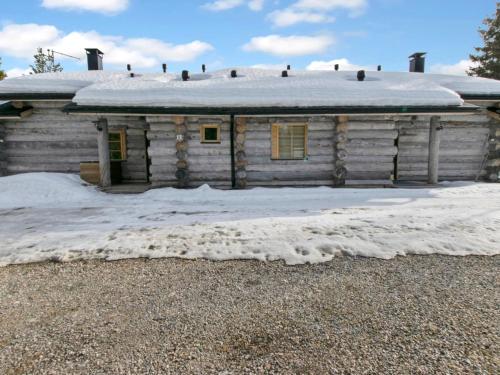 an old wooden house with snow on the ground at Holiday Home Peikkola by Interhome in Ruka