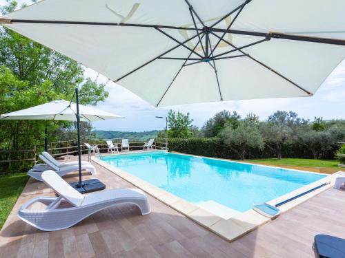 einen Pool mit einem Sonnenschirm und Liegestühlen sowie einem Pool in der Unterkunft Holiday Home Il Rifugio - La Loggia - CAD102 by Interhome in Casalbordino