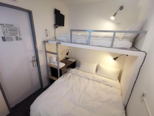 a small room with two bunk beds in it at Inn Cube - Taipei Main Station in Taipei