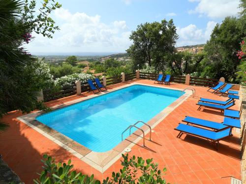 una piscina con tumbonas azules en Villa Bouganville by Interhome, en Badesi