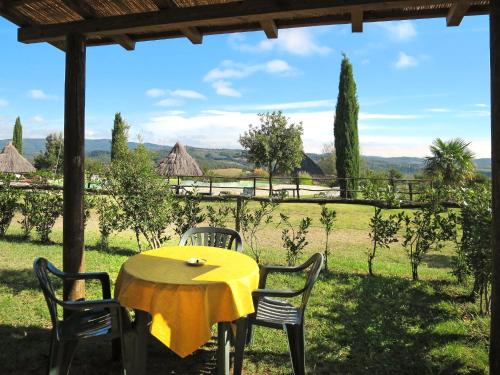 einen gelben Tisch mit Stühlen und Blick auf ein Feld in der Unterkunft Holiday Home Ginestre 11 by Interhome in Santo