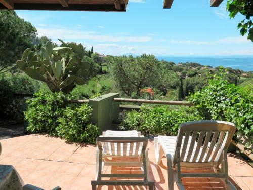 two chairs and a table on a patio overlooking the ocean at Holiday Home Piccola Oasi-3 by Interhome in Capoliveri
