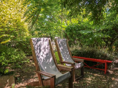 dwa krzesła siedzące obok czerwonej ławki w obiekcie Holiday Home L'Oté rouge - PLX105 by Interhome w mieście Plérin