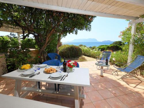un tavolo bianco con un piatto di cibo su un patio di Apartment Vista Tavolara 2 by Interhome a Pittulongu