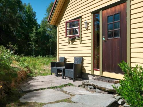 2 sillas sentadas en un patio junto a una casa en Holiday Home Rabbane - FJS504 by Interhome, en Nyttingsnes