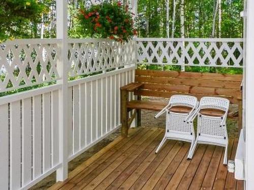 a porch with two chairs and a table and a bench at Holiday Home Halmesaari by Interhome in Kerkonjoensuu