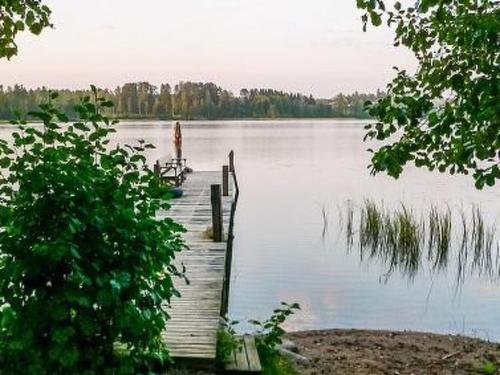a dock on a lake with a person standing on it at Holiday Home Halmesaari by Interhome in Kerkonjoensuu