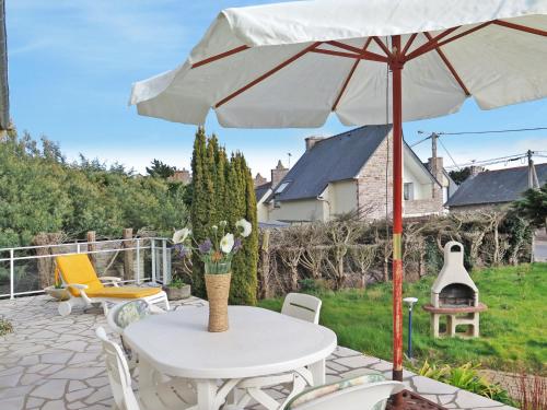 een patio met een tafel en een parasol bij Holiday Home Etoile de Mer - EQY101 by Interhome in Erquy