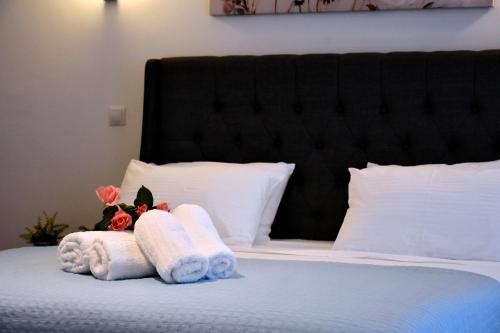 a bed with towels and flowers on top of it at The Blue Rooms in Áyioi Apóstoloi