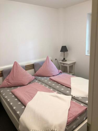 two beds in a room with pink and white pillows at Apartment in Wiek in Wiek auf Rügen