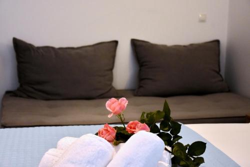 a table with pink flowers on it with a couch at The Blue Rooms in Áyioi Apóstoloi