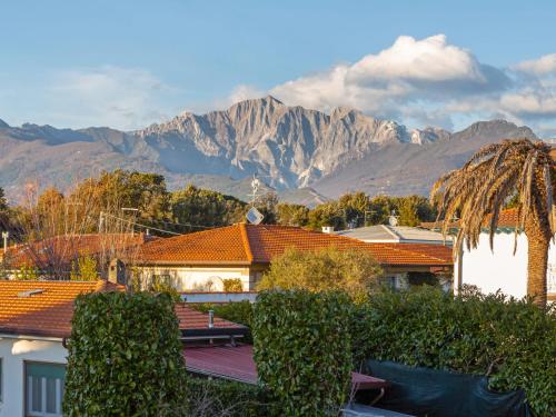 a view of a house with mountains in the background at Apartment Michelangelo II by Interhome in Marina di Pietrasanta