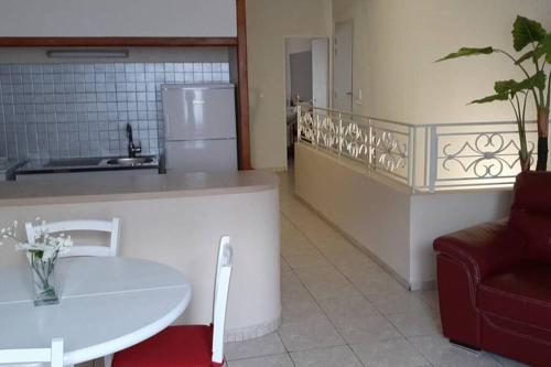 a kitchen with a white table and a refrigerator at Maison de village 60m2 pratique et confortable in Lapalme