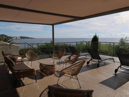 une terrasse avec des chaises, des tables et un parasol dans l'établissement Villa Farfalla by Interhome, à Sainte-Maxime