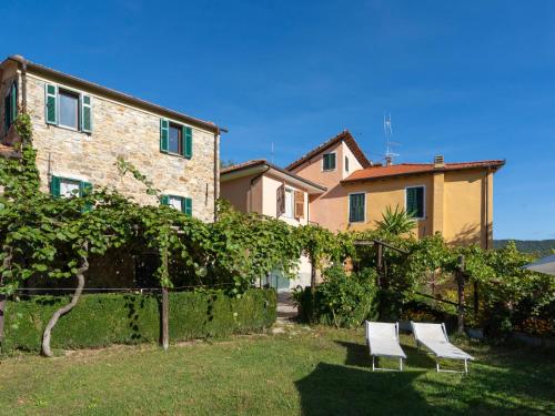 two white chairs in a yard next to a building at Holiday Home I Ciasi - VSP200 by Interhome in Ville San Sebastiano