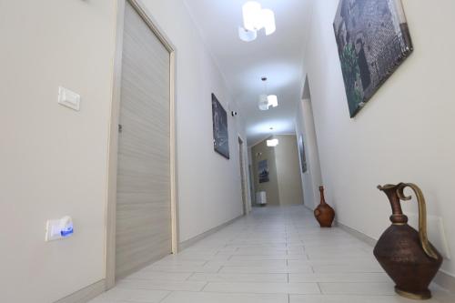 a hallway with white walls and a vase on the floor at Residenza Atena Tropea in Tropea