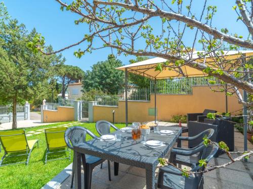 un patio con tavolo e sedie in un cortile di Holiday Home Pellicano by Interhome a Olbia