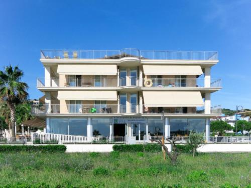 a building on the beach with palm trees at Apartment Casa del Mar-1 by Interhome in Roseto degli Abruzzi