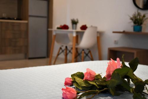 a bunch of pink flowers sitting on a bed at The Blue Rooms in Áyioi Apóstoloi