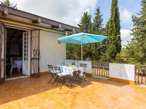 een tafel en stoelen met een parasol op een patio bij Holiday Home Bouganville by Interhome in Rosciano
