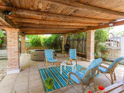 een patio met stoelen, een tafel en een hot tub bij Holiday Home Bouganville by Interhome in Rosciano