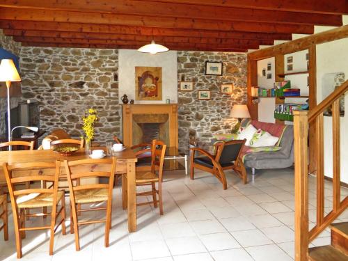 un salon avec une table et des chaises et une cheminée dans l'établissement Holiday Home Gîte des Oiseaux by Interhome, à Plouha