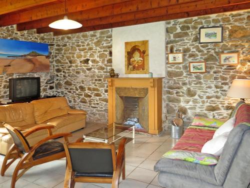 - un salon avec un mur en pierre et une cheminée dans l'établissement Holiday Home Gîte des Oiseaux by Interhome, à Plouha