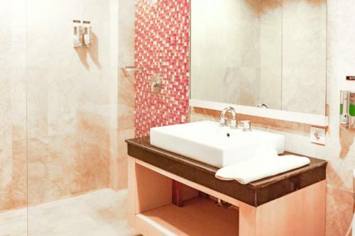 库塔KoolKost at Bypass Jimbaran - Minimum Stay 30 Nights的带水槽和淋浴的浴室