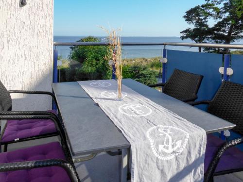 een tafel op een balkon met uitzicht op de oceaan bij Apartment Blaumuschel - LUB118 by Interhome in Lubmin
