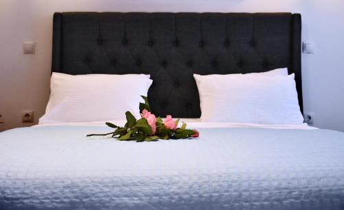 a bedroom with a bed with a flower arrangement on it at The Blue Rooms in Áyioi Apóstoloi