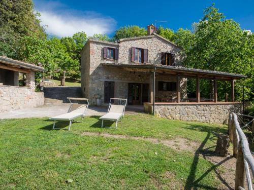 een oud stenen huis met stoelen in de tuin bij Holiday Home Casale Ulisse by Interhome in Roccastrada