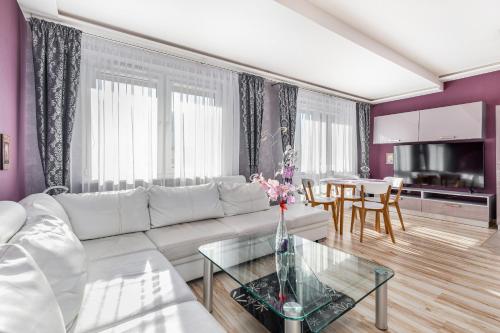 a living room with a white couch and a glass table at Osiedle Bocianie Gniazdo by Renters in Kołobrzeg