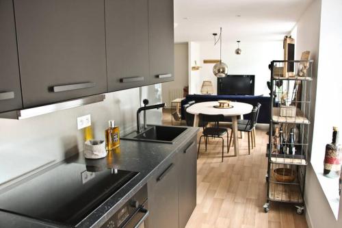 - une cuisine avec un évier et une table dans une chambre dans l'établissement A stylish apartment in the centre of town, à Montreuil-sur-Mer