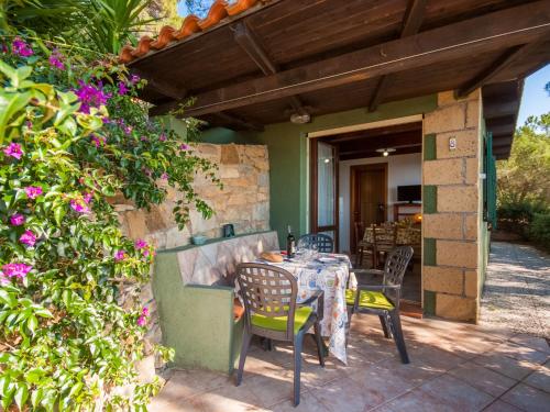 einen Tisch und Stühle auf einer Terrasse mit Blumen in der Unterkunft Holiday Home Piccola Oasi-5 by Interhome in Capoliveri