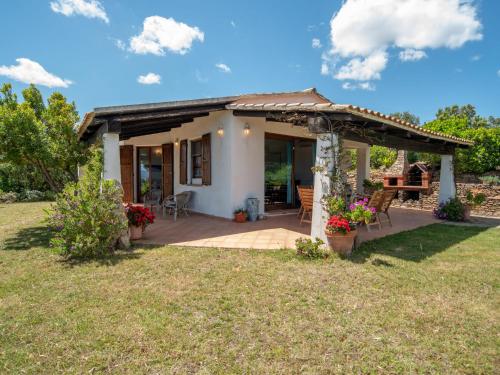 a small house with a patio and a table at Holiday Home Gardenia by Interhome in Pittulongu