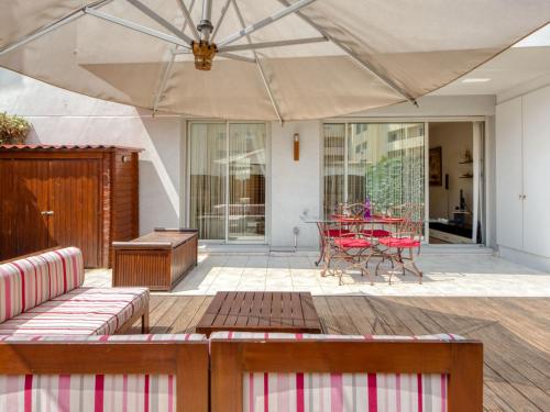 a patio with a table and a large umbrella at Apartment Les allées du Cap-3 by Interhome in Antibes