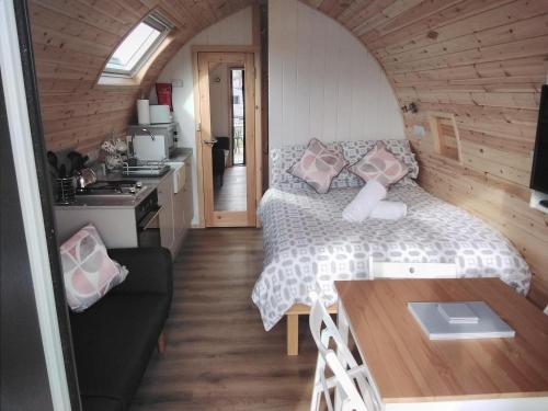 a bedroom with a bed and a table in a room at Glamping Pods in Cromer