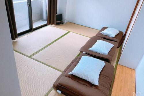 two brown beds in a room with a window at Esperanza 204号室 in Tokyo