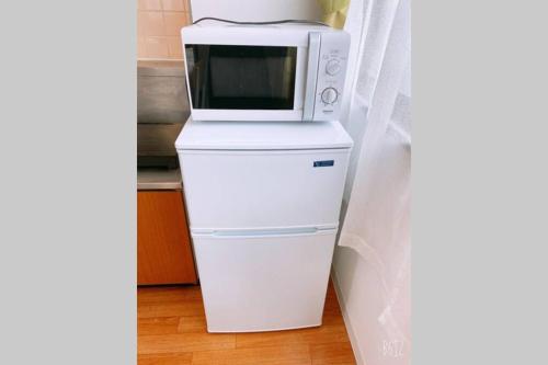 a microwave sitting on top of a refrigerator at Esperanza 204号室 in Tokyo