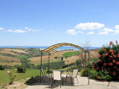 une table et des chaises assises sous une arche dans un champ dans l'établissement Holiday Home Serrani-4 by Interhome, à Cologna