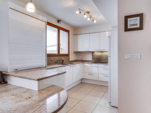 uma cozinha com armários brancos e uma grande janela em Holiday Home La Maison de l'Etang by Interhome em Gruissan